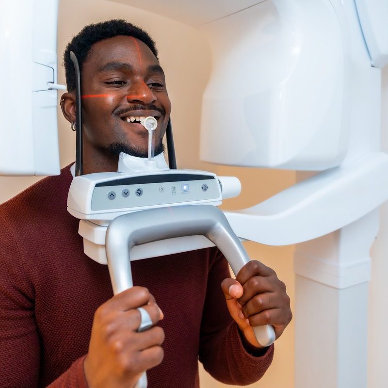 Patient smiles while undergoing a dental x ray scan in a modern dental clinic, demonstrating advanced oral healthcare technology