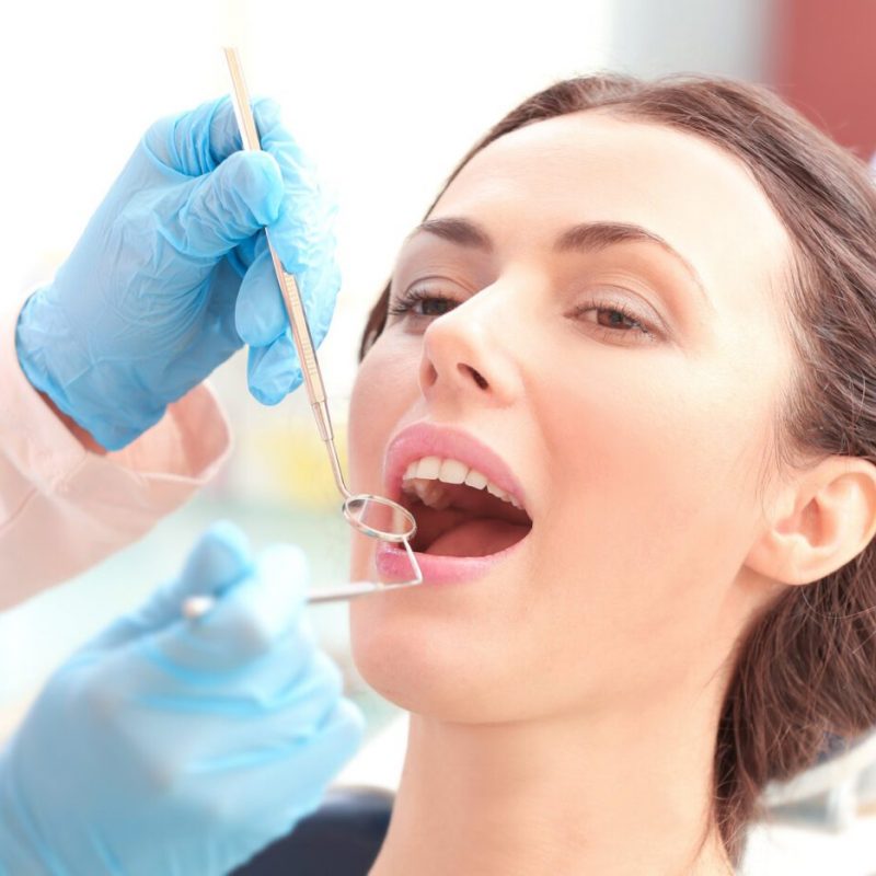 Dentist examining patient's teeth in clinic