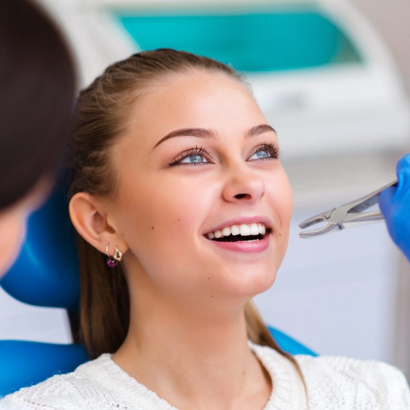 Tooth extraction beautiful girl in dentistry.