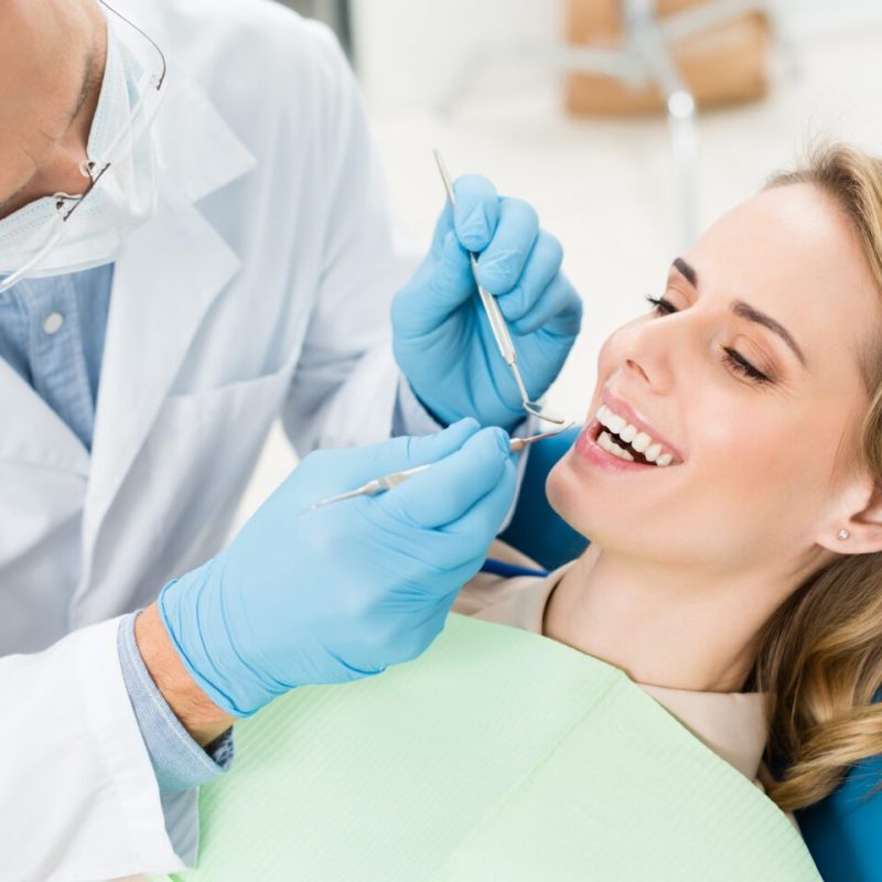 Doctor treats patient teeth in modern dental clinic