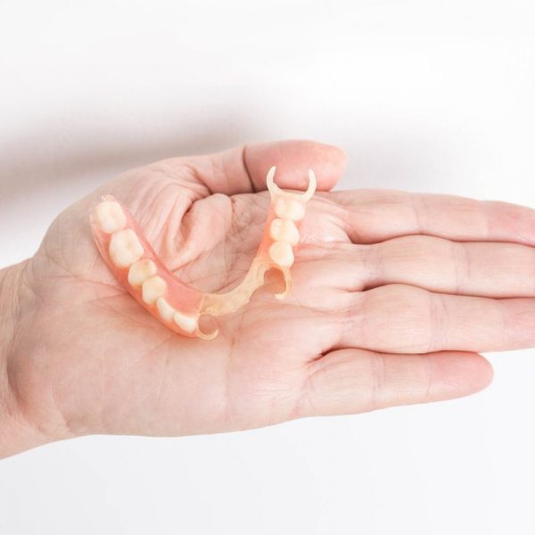 flexible nylon denture on female hand. Removable dentures flexible, devoid of nylon, hypoallergenic exempt from monomer