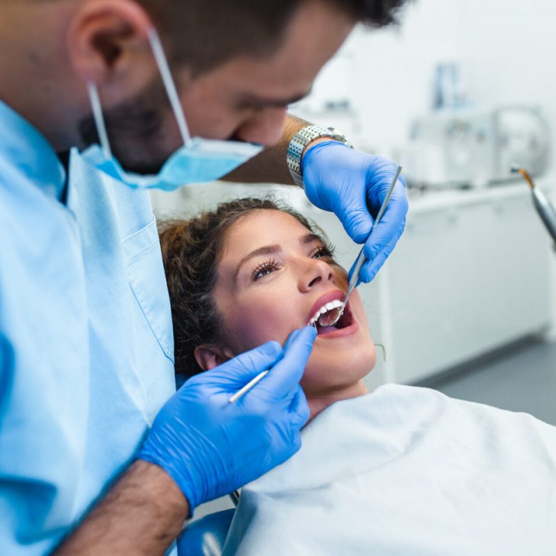 Beautiful young woman having dental treatment at dentist's office.