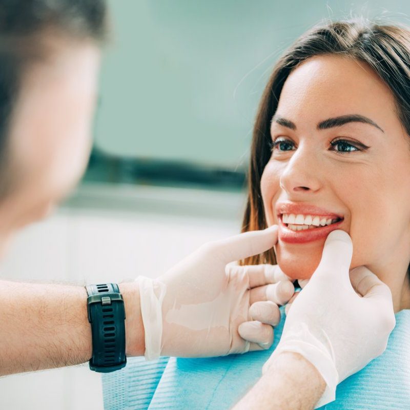 Dentist with beautiful female patient Young smiling woman with beautifiul teeth, having a dental inspection