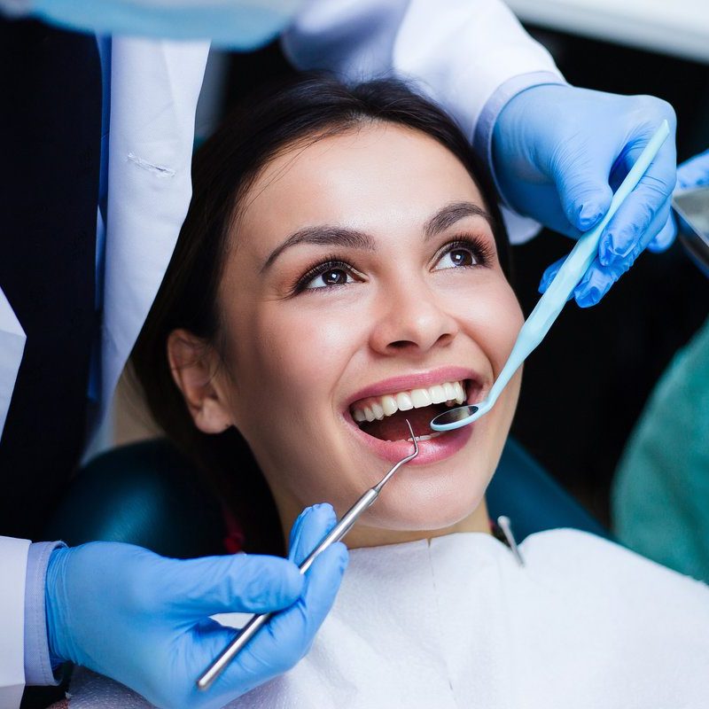 Perfect smile! Part of dentist examining his beautiful patient in dentist’s office
