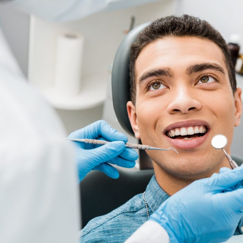 cheerful african american man with during examination in dental clinic
