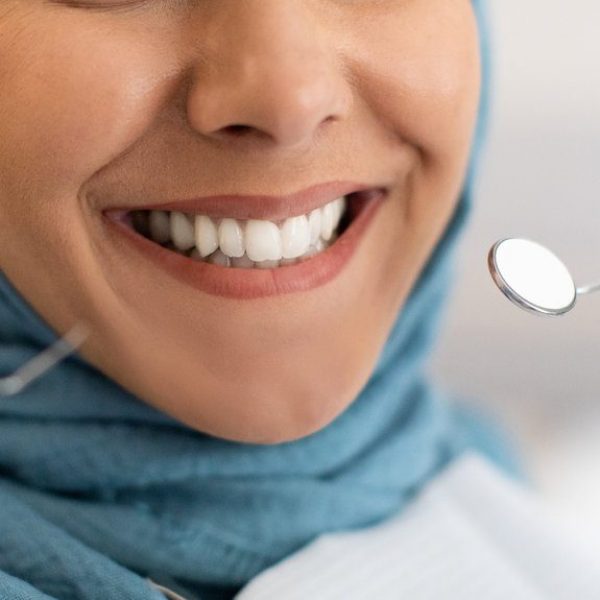 Smile Makeover. Closeup Shot Of Smiling Woman In Hijab During Dental Check Up In Modern Clinic, Cropped Image Of Muslim Female Patient Getting Treatment In Stomatologic Cabinet, Panorama