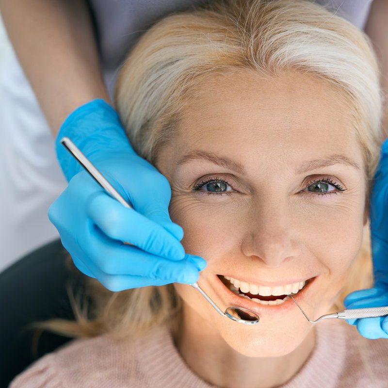 Close-up of pretty patient is having teeth examined by dentist in cabinet