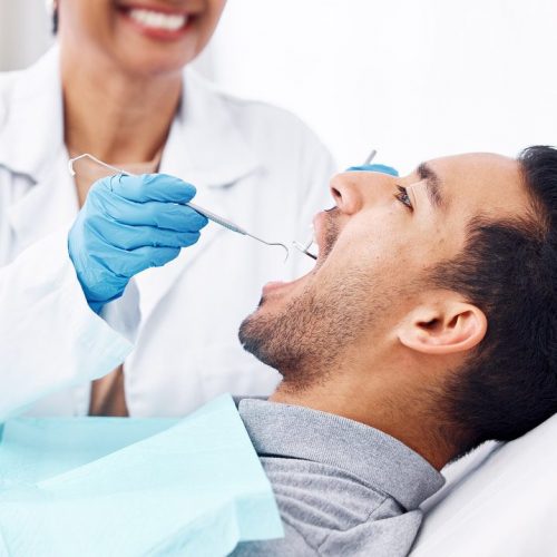 Man, dentist and check teeth with tools for dental cosmetics, healthcare assessment or medical consulting. Patient, tooth or open mouth in oral cleaning with mirror, excavator or orthodontics surgery.