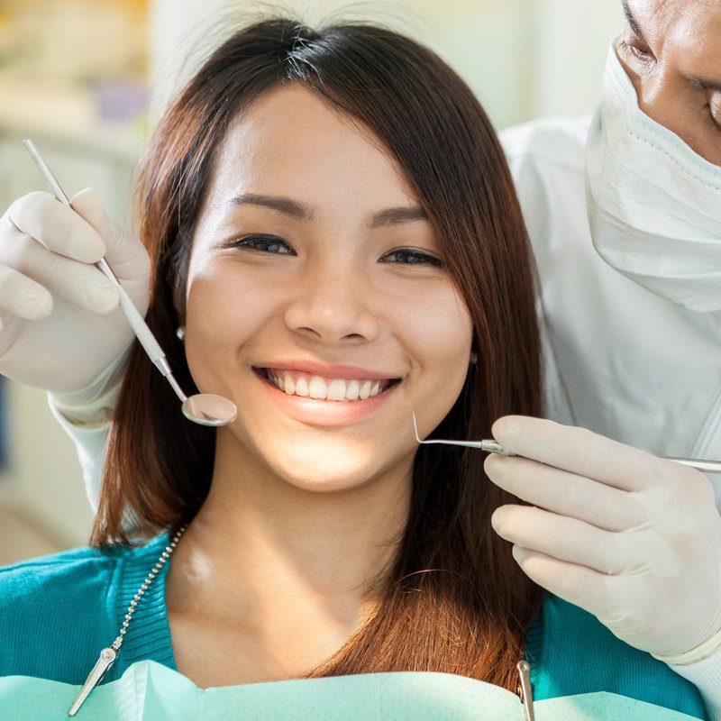 Portrait of smiling asian woman sitting at the dentist