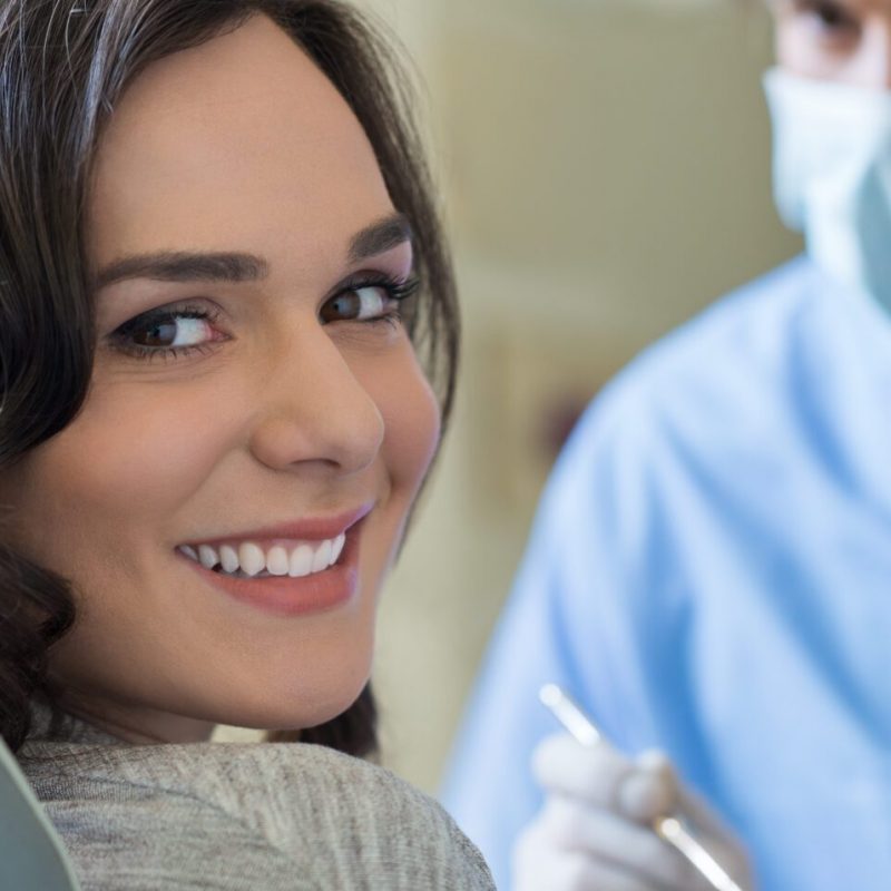 Smiling young woman receiving dental checkup